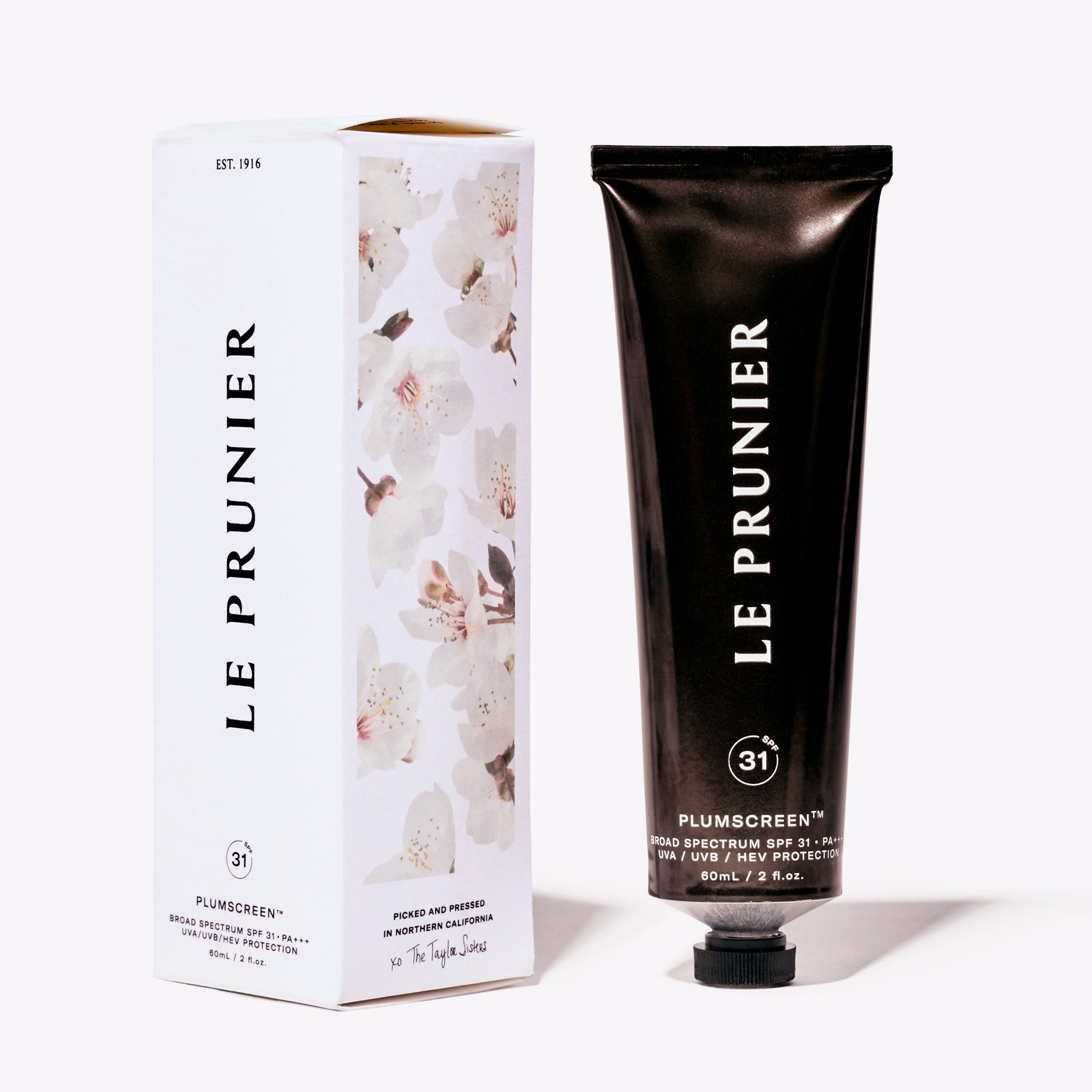 Le Prunier Plumscreen SPF 31+++ beside its white package with abstract flower imagery and black embossed branding.