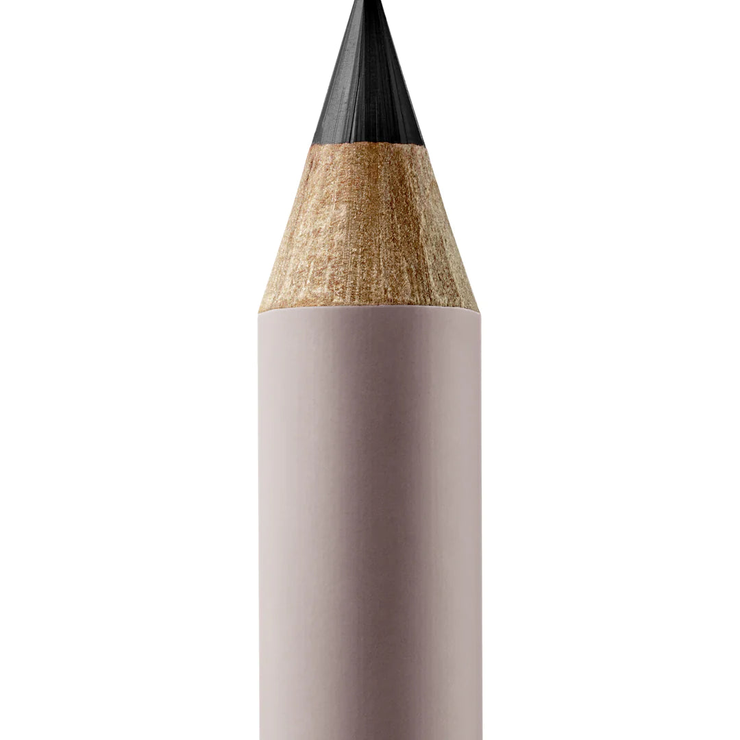 A sharpened Manasi 7 Lip and Eye Definer Petunia pencil showing the charcoal black color. The pencil itself is dark pink.