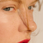 Close-up of Manasi 7 All Over Colour Alizarin on a woman with light complexion's lips, cheeks, and eyes.