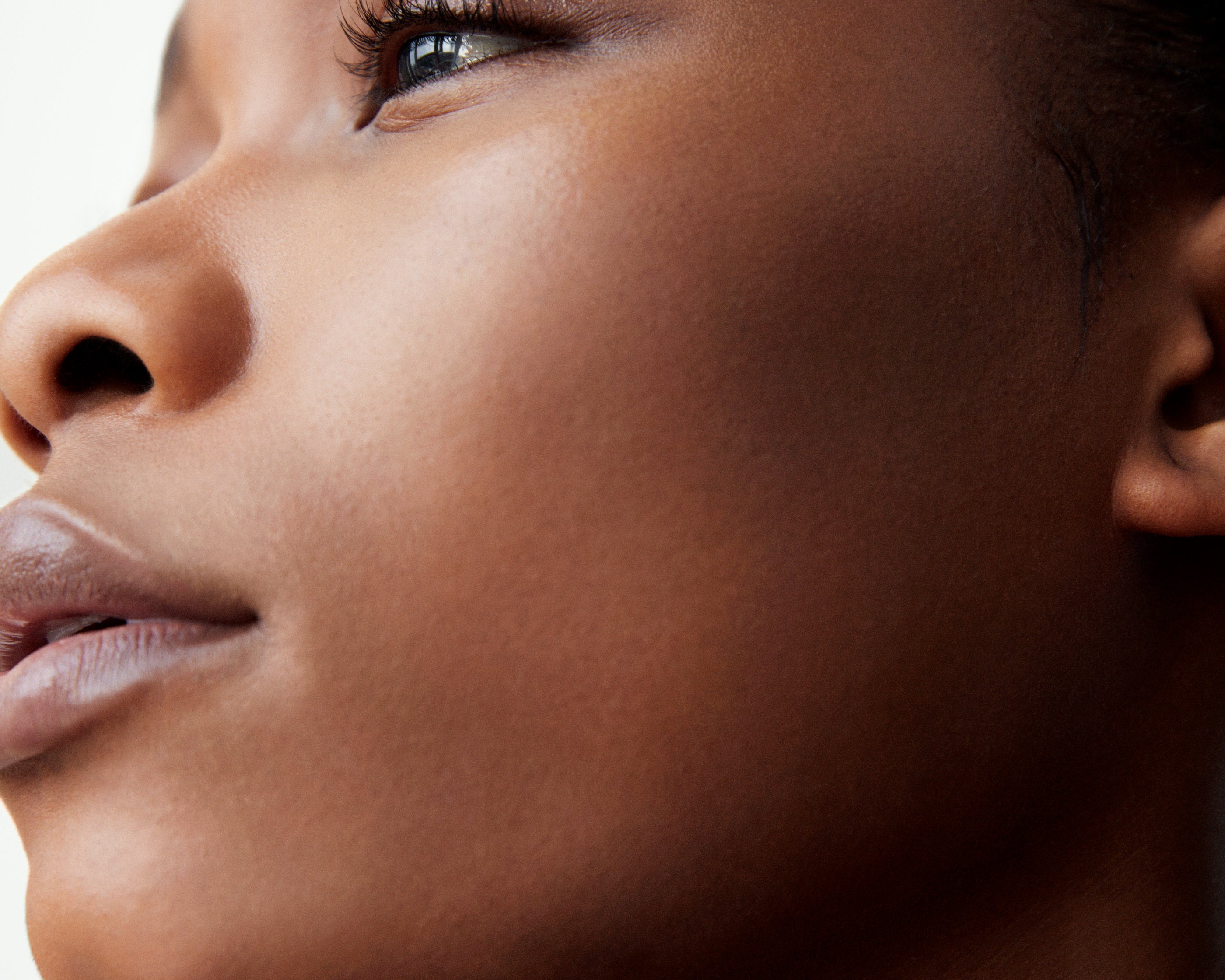 Side profile of a woman with dark complexion wearing Manasi 7 All Over Colour Chamoisee on her lips, cheeks, and eyes.