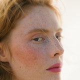 Side profile of a woman with light complexion wearing Manasi 7 All Over Colour Fuchsine on her lips, cheeks, and eyes.