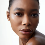 A close-up of a woman with dark complexion wearing Manasi 7 Silk Finish Powder, showcasing its translucent semi-matte finish.