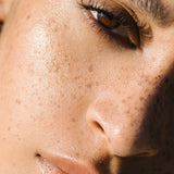 Close-up of a sunlit woman with medium complexion wearing Manasi 7 Bronzelighter Roseate.
