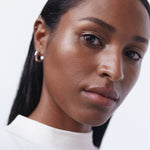 A woman with a dark complexion showcasing the radiant finish of Manasi 7 Strobelighter Heliconia.