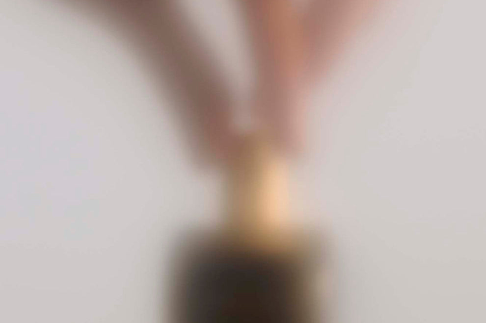 
  
  Osmé Fragrance PIRYTE showing hands placing the perfume on a counter after use.
  
