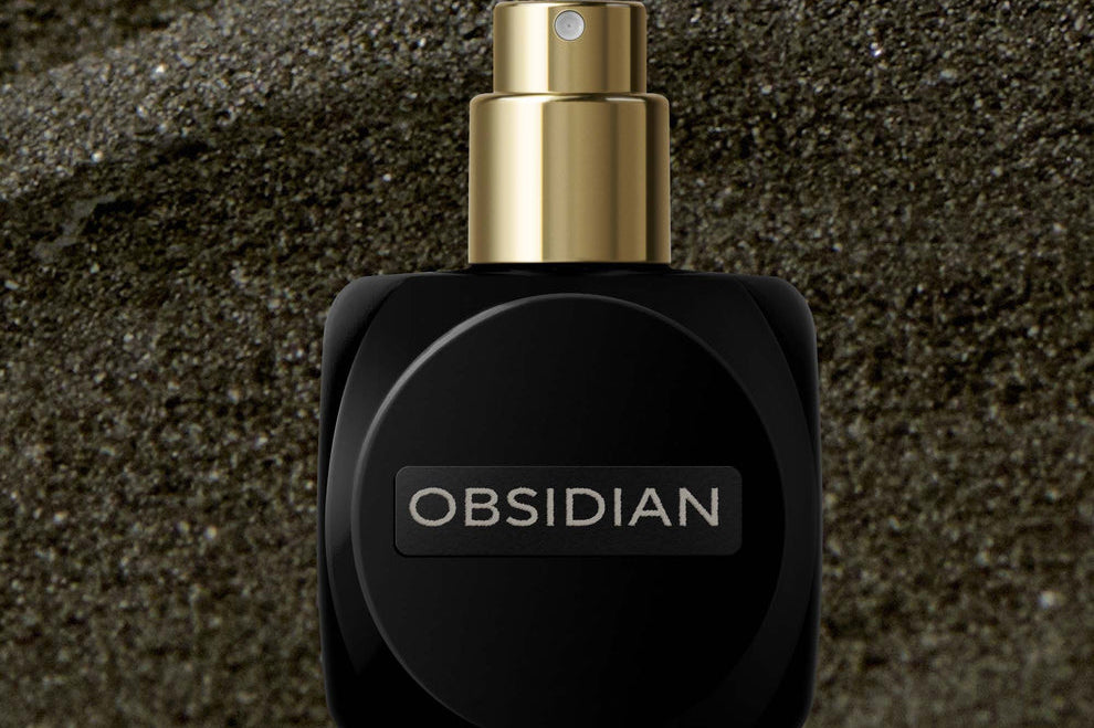 
  
  Black Osmé Fragrance Obsidian perfume bottle on sand with cap off
  
