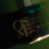 
  
  Osmé Fragrance TURMALI in motion displaying movement on a green background.
  
