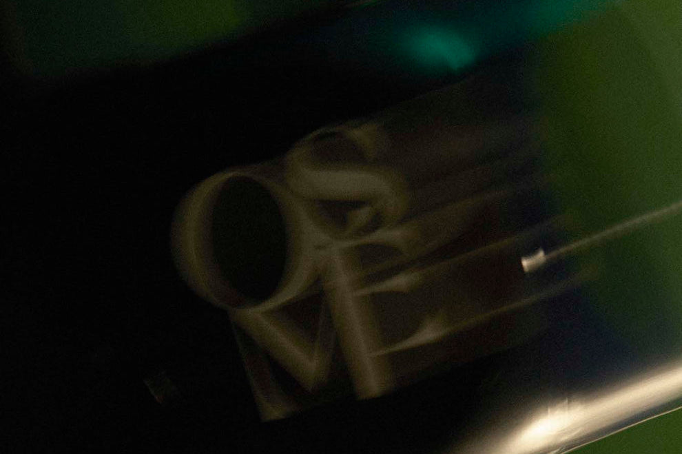 
  
  Osmé Fragrance TURMALI in motion displaying movement on a green background.
  
