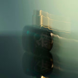 
  
  Osmé Fragrance TURMALI in blurred motion displaying gold and green reflection.
  
