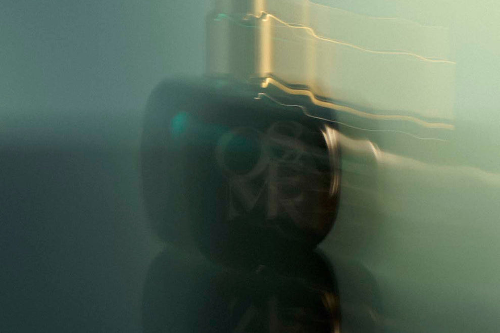
  
  Osmé Fragrance TURMALI in blurred motion displaying gold and green reflection.
  
