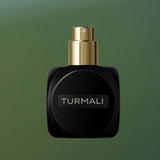 
  
  Black Osmé Fragrance TURMALI perfume bottle with cap off on a green background
  
