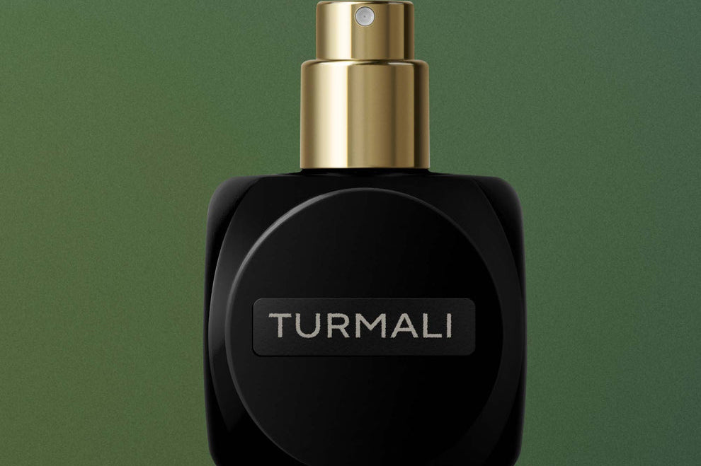 
  
  Black Osmé Fragrance TURMALI perfume bottle with cap off on a green background
  
