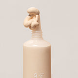 
  
  Close-up of Ere Perez Lychee Creme Corrector Uno being squeezed out of its tube.
  
