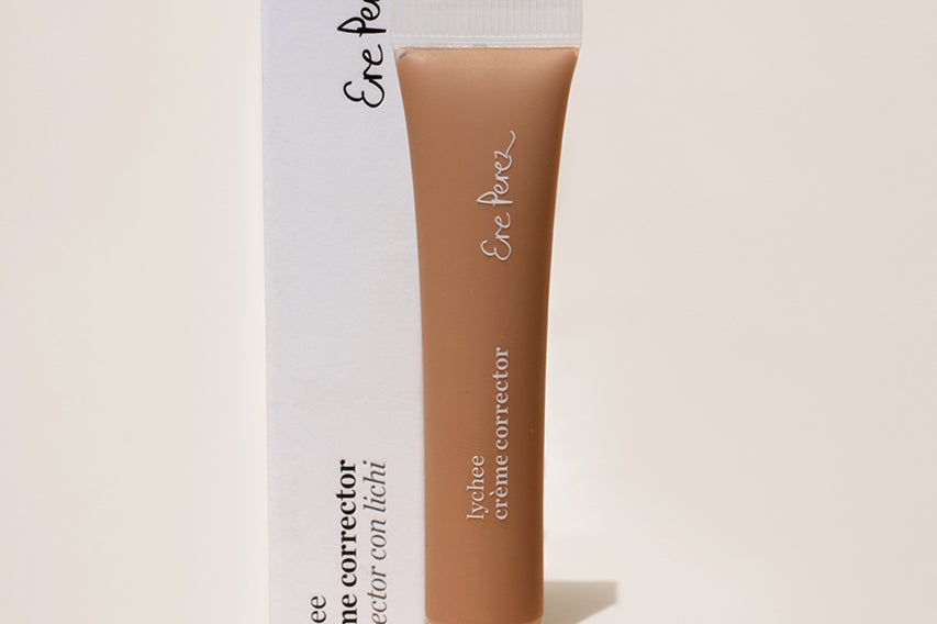 
  
  Ere Perez Lychee Creme Correctors Cinco comes in a clear squeeze tube with a white screw-on top, standing with its white box.
  
