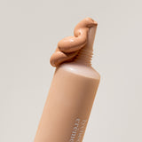 
  
  Close-up of Ere Perez Lychee Creme Corrector Cinco being squeezed out of its tube.
  
