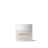 
  
  Omorovicza Cushioning Day Cream comes in a frosted glass compact jar with black branding text and a white screw-on top.
  
