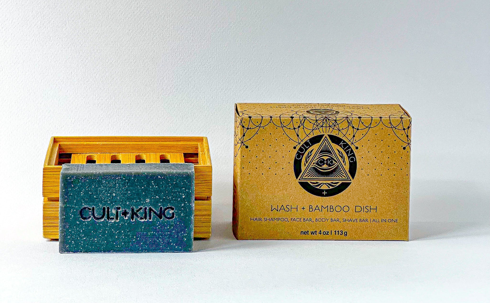 
  
  The textured Cult + King Shampoo Bar and slatted bamboo dish beside the set's geometrically patterned cardboard package.
  
