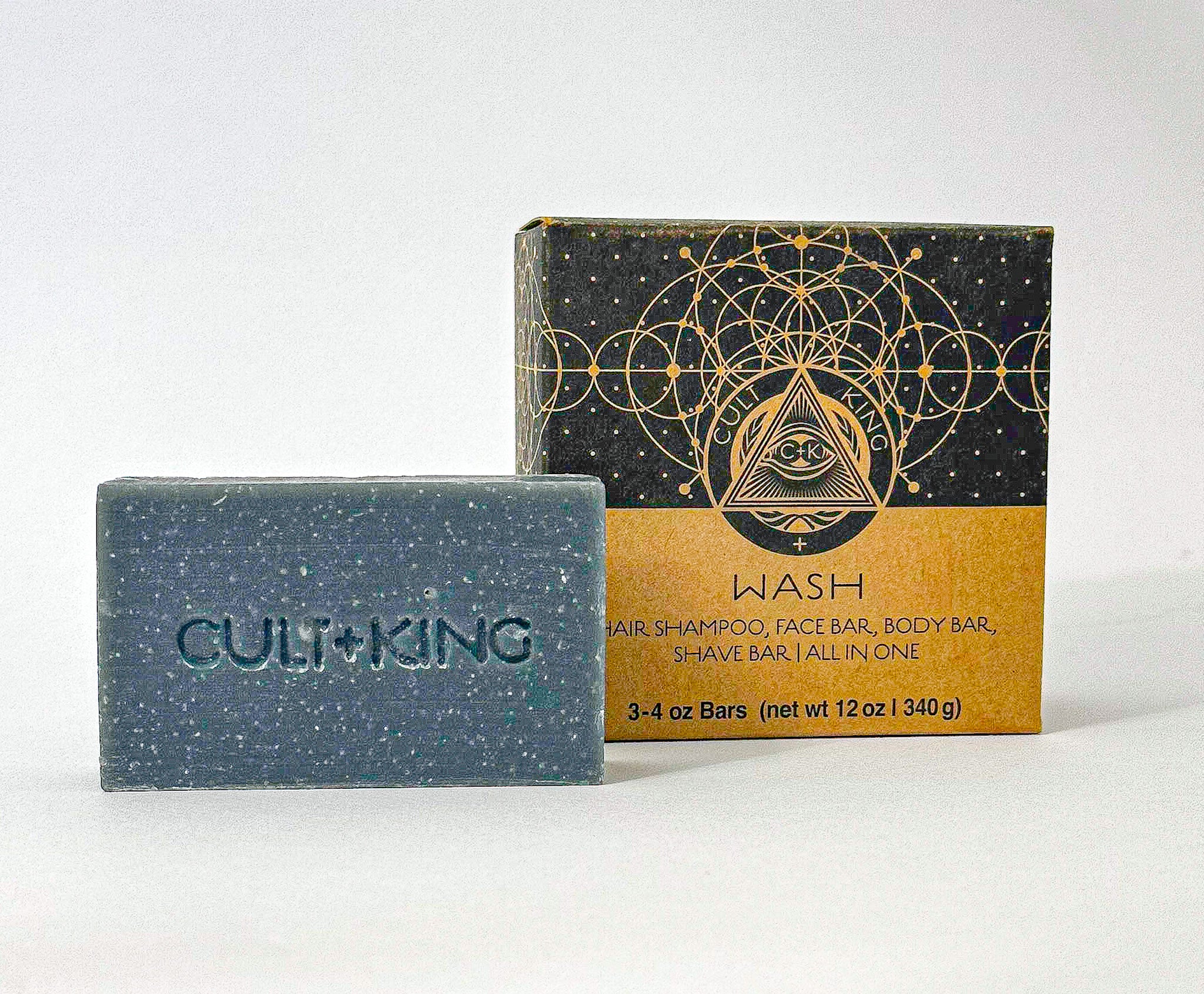 
  
  Cult + King's dark blue Shampoo Bar with an embossed logo next to its abstract patterned black and cardboard package.
  
