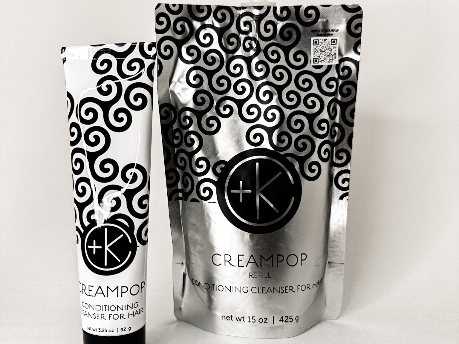 
  
  Cult + King CREAMPOP Cleansing Conditioner in a black-and-white swirl-patterned squeeze tube, beside its silver refill pouch.
  
