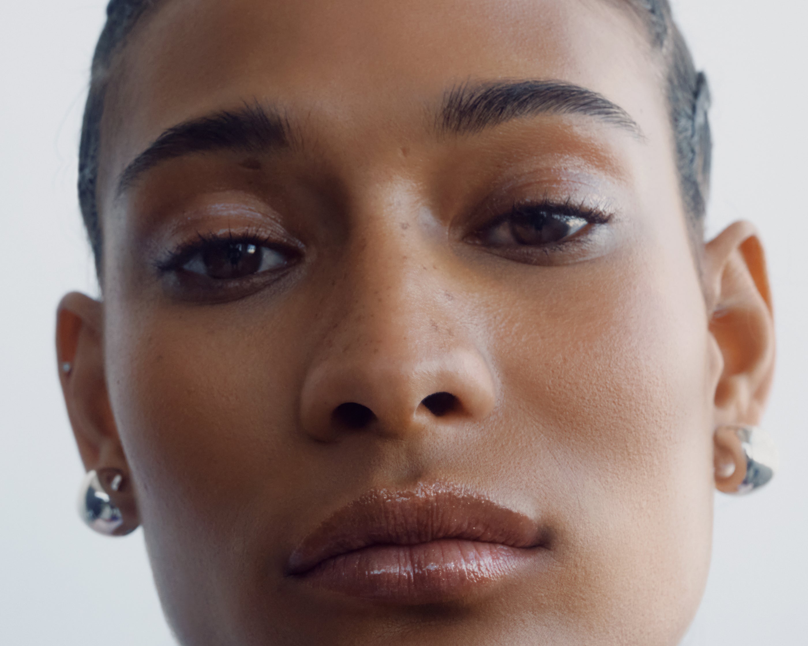 
  
  Close-up of a woman's face with braided hair showing Chameli Tinted Potion on lips, cheeks, and eyes against a white background
  
