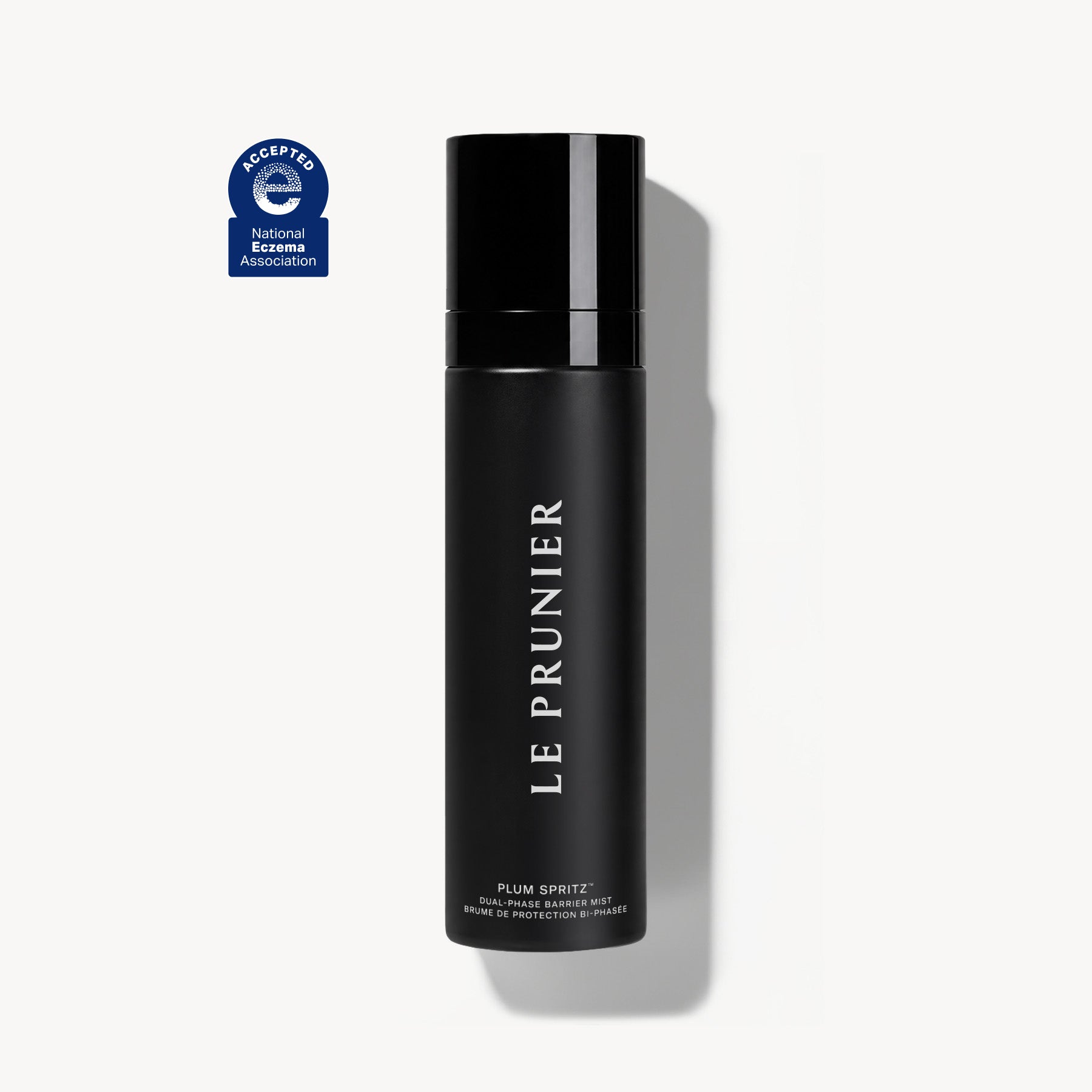 
  
  Black bottle of Le Prunier Plum Spritz on a white background with a blue and white logo  featuring National Eczema Society approved above it.
  
