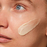 
  
  A creamy, ivory-colored swatch of Omorovicza Rejuvenating Night Cream on a woman's cheek.
  
