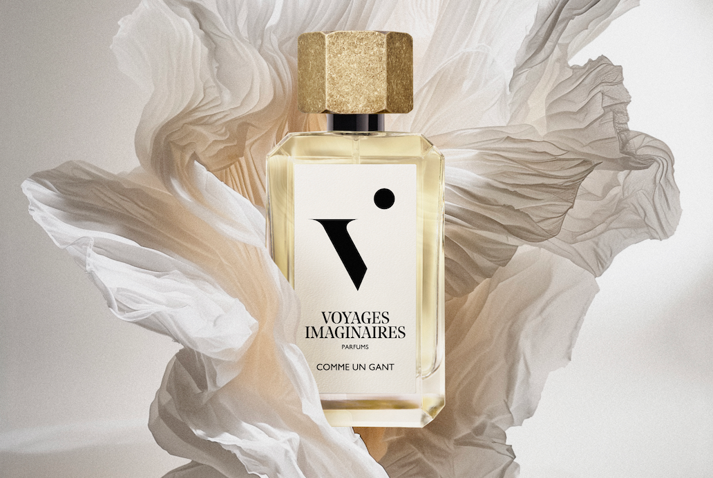 
  
  A bottle of Comme Un Gante gracefully set within a paper flower sculpture under soft studio lighting.
  
