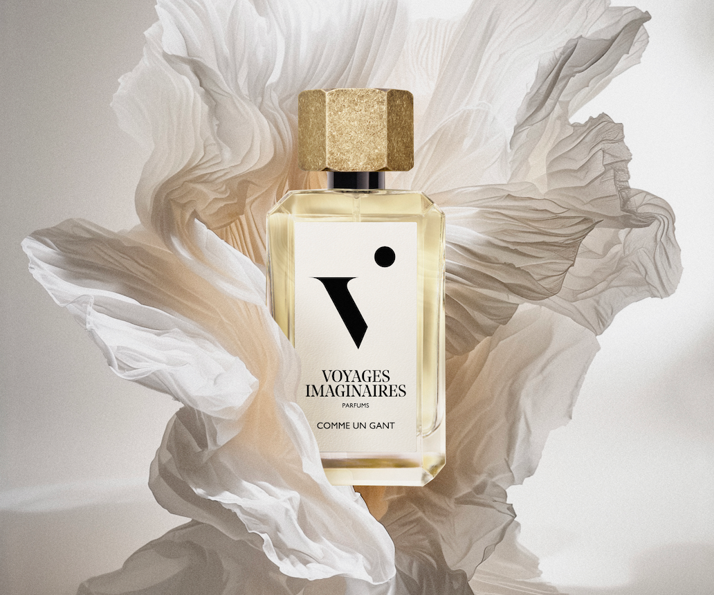 
  
  A bottle of Comme Un Gante gracefully set within a paper flower sculpture under soft studio lighting.
  
