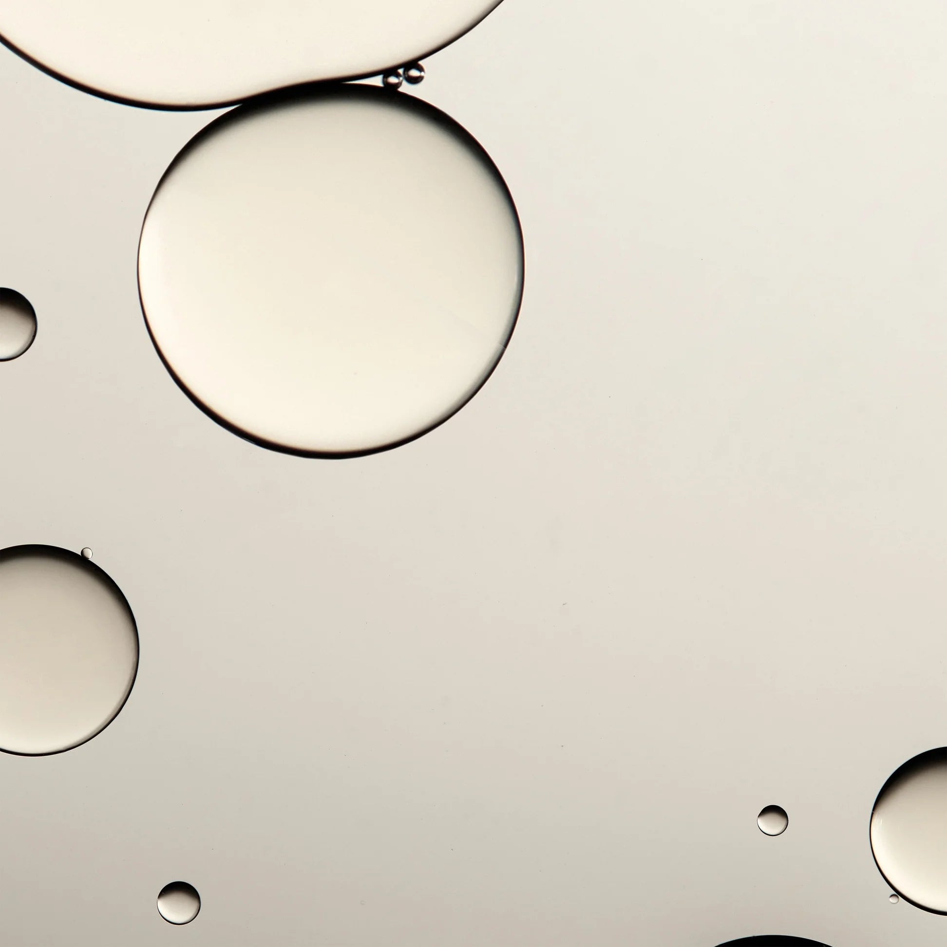 
  
  Translucent droplets of Omorovicza Queen of Hungary Mist, Queen Essence, and Omoressence showcasing their light, watery texture.
  
